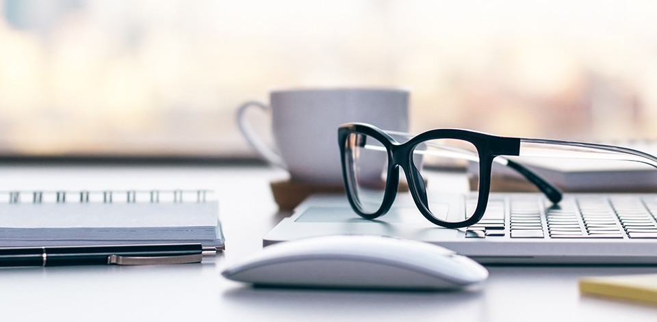 Glasses resting on top of laptop